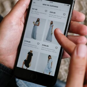 A person browsing clothing options on a smartphone for online shopping.